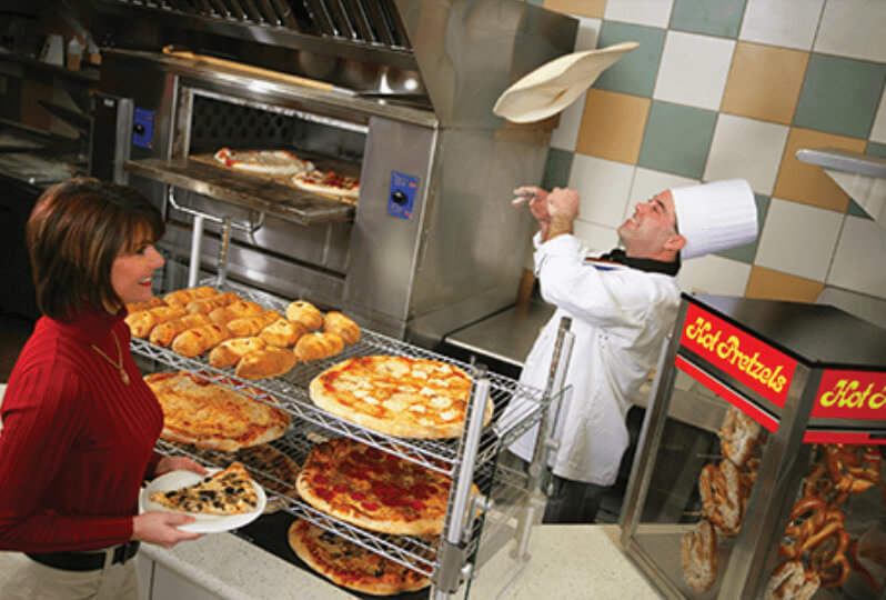 Cook tossing pizza dough at Pluto’s Pizzeria