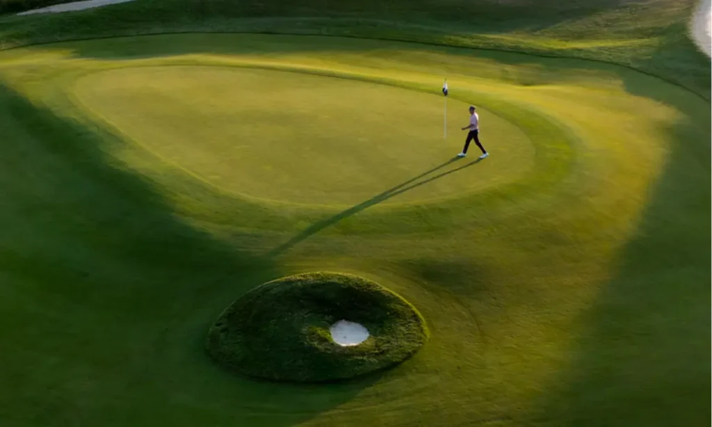 Golfer approaching the hole on a green