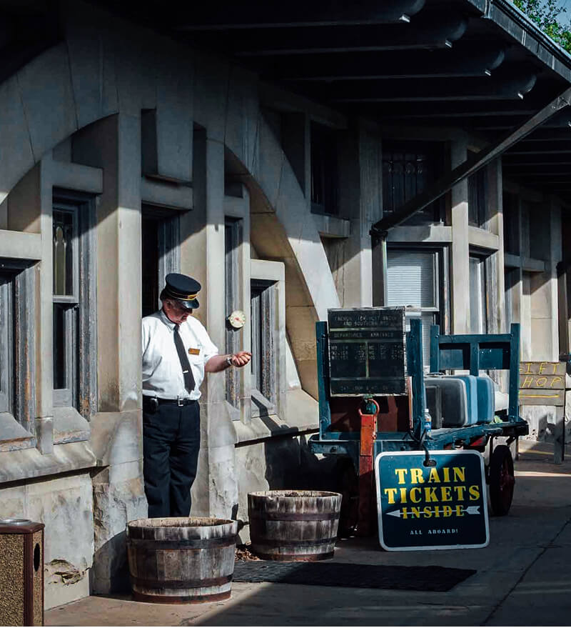 A train ticket salesperson waiting for the train to arrive