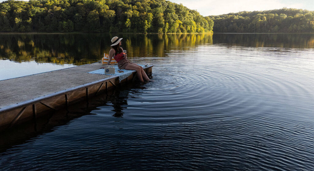 A woman sitting on a dock on a lake
