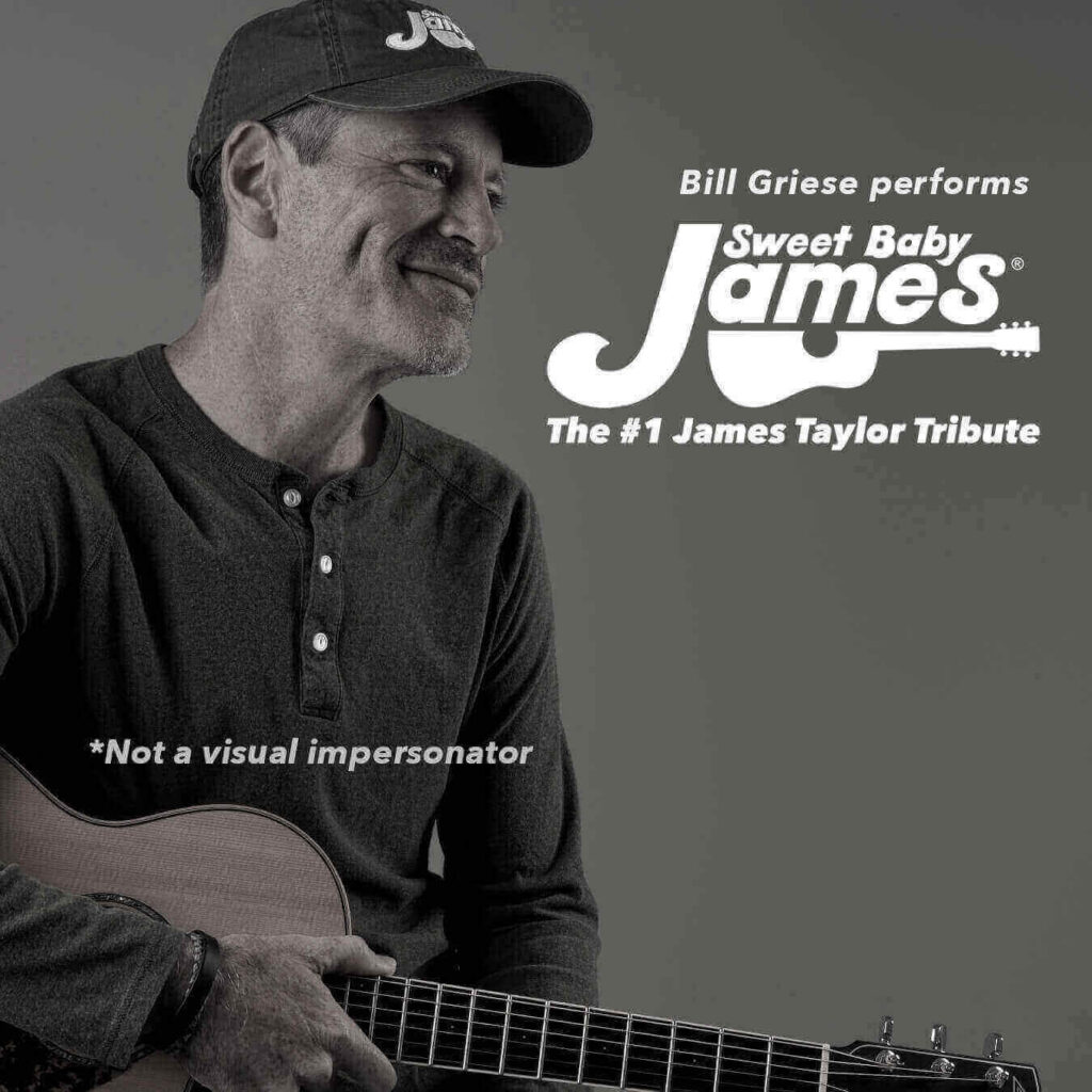 A man in a hat sitting with a guitar in his lap